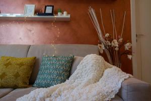 La Dotta Apartments في بولونيا: بطانية بيضاء جالسة فوق الأريكة