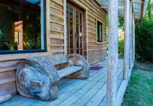 un banco de piedra sentado en el porche de una casa en Rincón del Gaucho en Hornopiren
