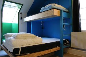 
a bed in a room with a blue wall at Globalhagen Hostel in Copenhagen
