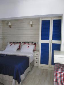 a bedroom with a bed with blue blinds at Losta Sahil Evi 2 in Selimiye