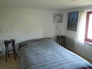 1 dormitorio con 1 cama con 2 mesas y una ventana en Les Rosiers, en Eschbourg