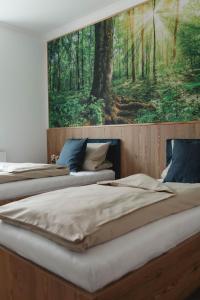 two beds in a room with a painting on the wall at Heilotel in Heilbad Heiligenstadt