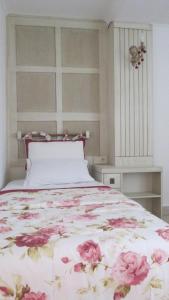 a bedroom with a bed with pink flowers on it at Losta Sahil Evi 2 in Selimiye
