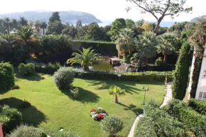 una vista aérea de un jardín con palmeras y arbustos en Nyrenoverad lägenhet med havsutsikt en Villefranche-sur-Mer