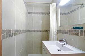 y baño blanco con lavabo y ducha. en Studio Panier 1970 en Marsella