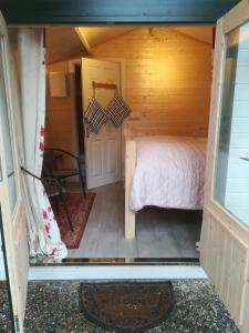 a bedroom in a log cabin with a bed at Dunmore Gardens Log Cabins in Carrigans