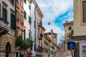 ヴェローナにあるCasa Perottiの青い看板と建物のある街道