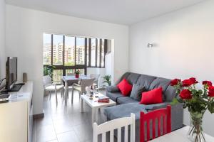 a living room with a couch and a table with red pillows at Almar Apartamento con AC, Los Cristianos in Los Cristianos