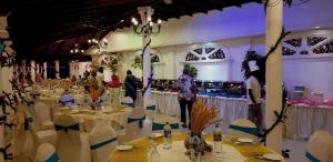 a large banquet hall with tables and chairs and people at Bougain Villa in Bentota +37 photos