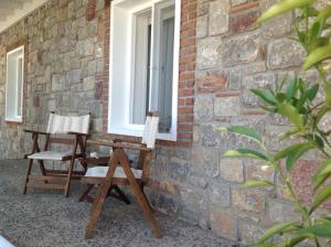 two chairs sitting on a porch next to a window at Losta Sahil Evi 2 in Selimiye
