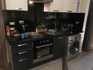 a kitchen with a sink and a washing machine at Pool View Apartment At British Resort Unit 221 in Hurghada