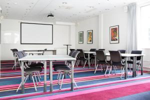 einen Konferenzraum mit Tischen, Stühlen und einem Whiteboard in der Unterkunft Comfort Hotel Eskilstuna in Eskilstuna