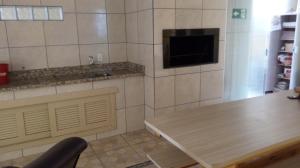 Una cocina con una mesa, un fregadero y un televisor. en Pousada Campanário, en Cambará 73 fotos más