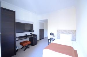 ein Hotelzimmer mit einem Bett und einem TV in der Unterkunft Bad Schauenburg in Liestal