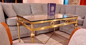 a gold and glass coffee table in front of a couch at Hotel Central in Nagykanizsa