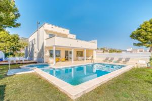 アルコセブレにあるPreciosa villa con piscina, jardín y vistas al mar WIFIの庭にスイミングプールがある家