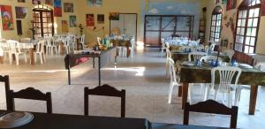 Fazenda São Felipe في ساو فرانسيسكو دو ايتابابوانا: غرفة طعام مع طاولات وكراسي في مطعم