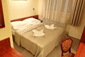 una habitación de hotel con una cama con arcos blancos. en Hotel Central en Nagykanizsa
