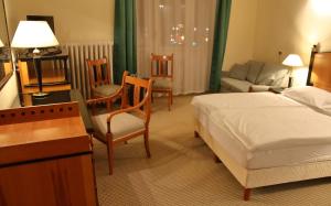 1 dormitorio con 1 cama, mesa y sillas en Hotel Central, en Nagykanizsa