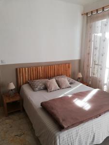 1 dormitorio con 1 cama grande y cabecero de madera en Maison d'hôtes Le Jas Vieux en Montfort