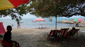 a group of people on a beach with chairs and umbrellas at Oasis de Tolú in Tolú