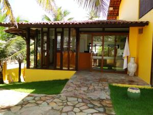 a house with a glass door and a patio at Pousada do Galo in Porto De Galinhas