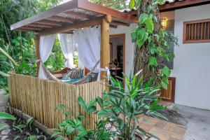 a porch of a house with a fence and a hammock at Pousada e Chalés Aquarius in Arraial d'Ajuda