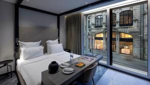 a hotel room with a bed and a table and a window at Porto Royal Bridges Hotel in Porto