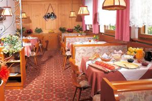 un restaurante con dos mesas con comida. en Pension Stamserhof en Nalles