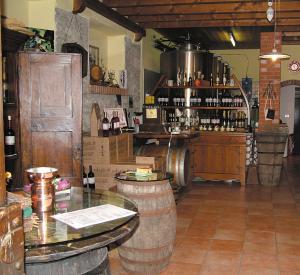 bodega con barriles y bar con botellas de vino en Agriturismo Le Caldane, en Colà di Lazise