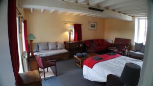 ein Wohnzimmer mit einem Bett und einer Couch in der Unterkunft Le Beugnon in La Pommeraie-sur-Sèvre