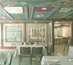 comedor con mesas y sillas y techo con techos pintados en Hotel Santa Cristina Petit Spa, en Canfranc-Estación