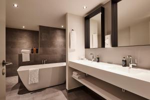 a bathroom with two sinks and a large mirror at Comwell Kongebrogaarden in Middelfart