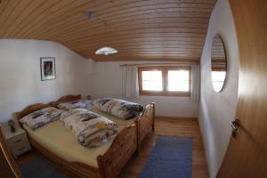 two beds in a room with a wooden ceiling at Ferienwohnung Rigoleth in Disentis