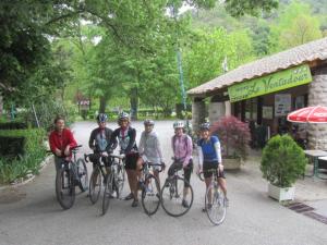 a group of people riding bikes in front of a building at Camping Le Ventadour in Meyras