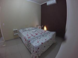 a small bedroom with a bed with a candle on it at Flat La Fazenda in Canoa Quebrada
