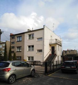 a building with two cars parked in a parking lot at MORSKIE FALE in Kołobrzeg