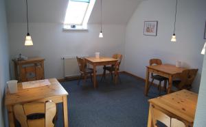 a room with wooden tables and chairs and a window at Pension Am Thieberg in Landolfshausen