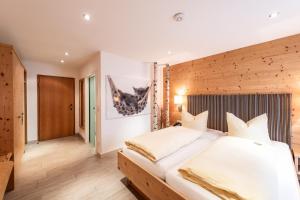 a bedroom with a large bed with a wooden headboard at Hotel Ariadne in Rosenheim