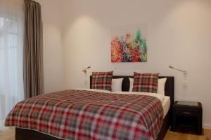 a bedroom with a bed with a plaid blanket at Hotel Seegarten in Barmstedt