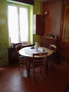 a kitchen with a table and chairs and a window at Chambre d'hôtes Chez Léon pour 1 à 4 personnes in Chaulgnes