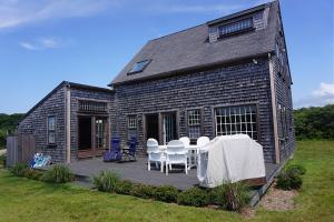 une maison avec une table et des chaises sur une terrasse dans l'établissement 9 Green Hollow Road, à Nantucket