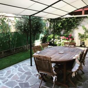 einen Holztisch und Stühle unter einem Sonnenschirm in der Unterkunft Casa Giulietta in Spilamberto