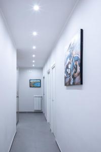 un couloir avec des murs blancs et une peinture murale dans l'établissement Damè, à Salerne