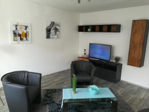 a living room with two chairs and a television at Apartment 28 o M in Castrop-Rauxel