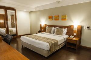 a hotel room with a large bed and a chair at Quality Porto Alegre in Porto Alegre