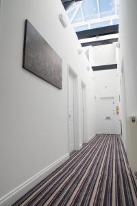 a hallway with white walls and a flat screen tv on the wall at TLK Apartments & Hotel - Beckenham in Beckenham
