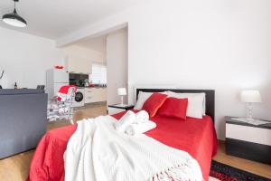 1 Schlafzimmer mit einem roten Bett und 2 Handtüchern in der Unterkunft Casa Annie in Arco da Calheta