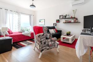 ein Wohnzimmer mit einem Sofa und einem roten Teppich in der Unterkunft Casa Annie in Arco da Calheta