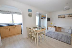 a kitchen and dining room with a table and chairs at Beach View Apartments in Porthtowan
